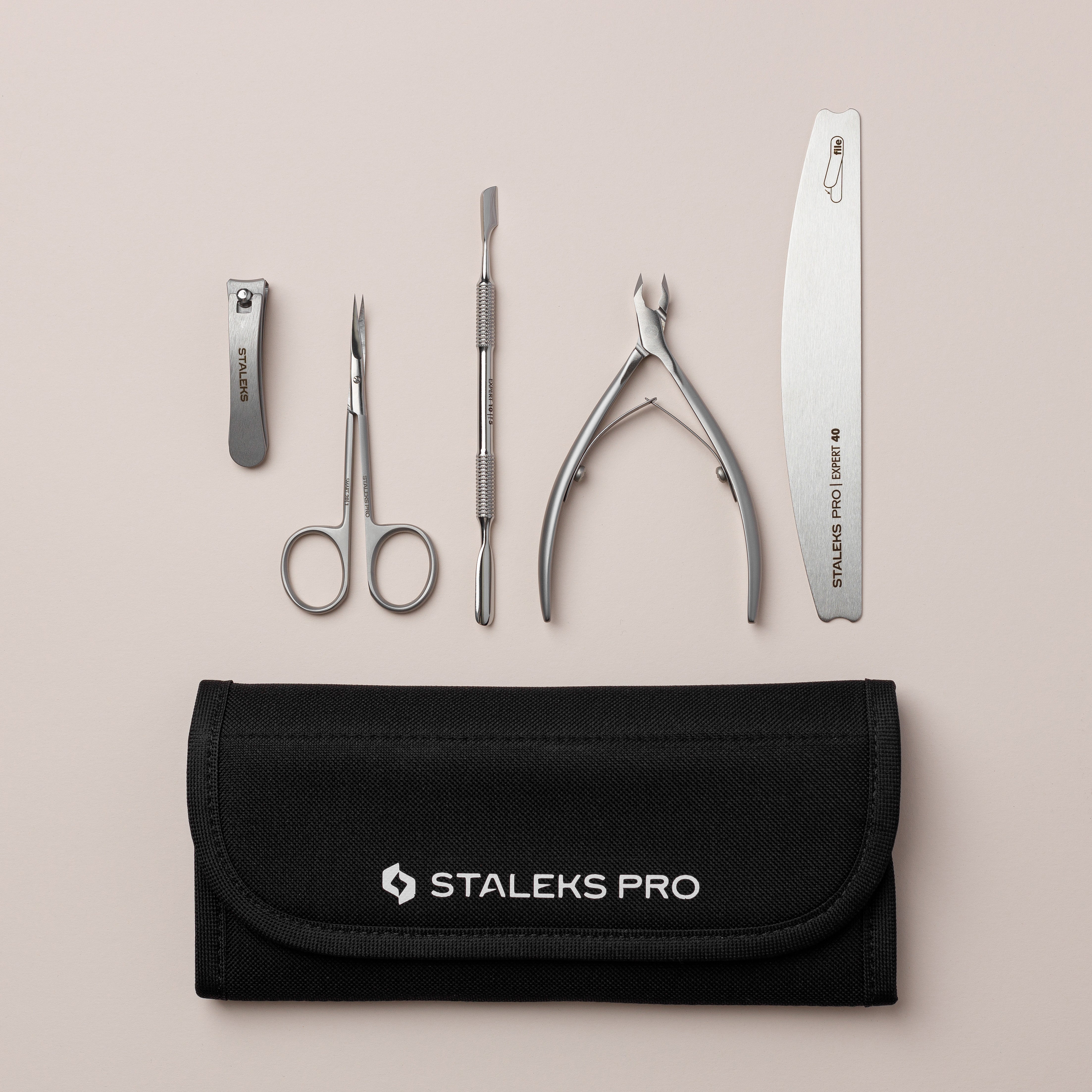 Set of nail care tools with a Staleks Pro case on a beige background